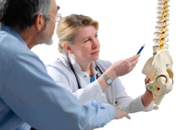 Il medico consulta il paziente sui segni di osteocondrosi della colonna vertebrale toracica